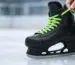 Hockey-Schlittschuh mit farbigen gewachsten Schnürsenkeln beim Schnüren
